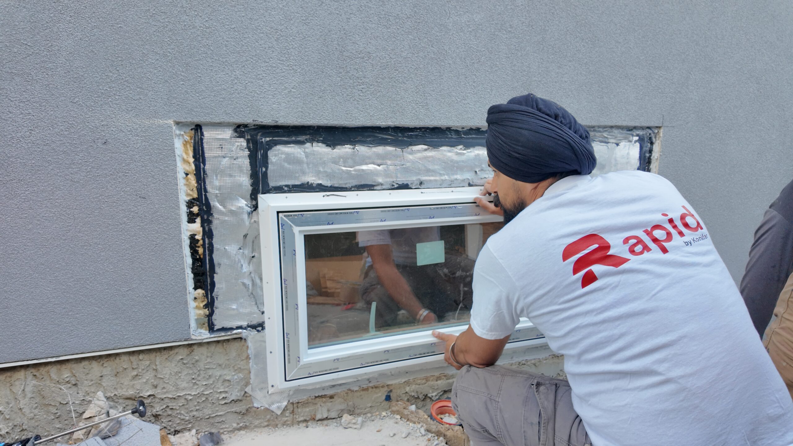 technician installting a basement window